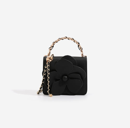 Black mini crossbody bag with 3D flower decor and luxury gold metal chain handle.