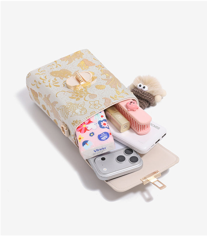 Elegant gold scale mini crossbody bag open with phone, cosmetics, and tissues inside.