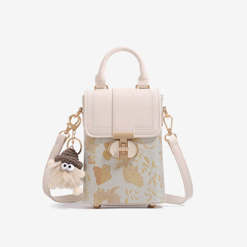 Elegant gold scale mini crossbody bag with white top handle and fluffy charm